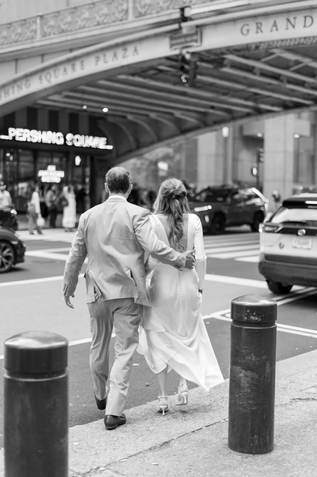 Bride and groom walking hand in hand past Grand Central Terminal, NYC wedding photography by Ashley Film Studios