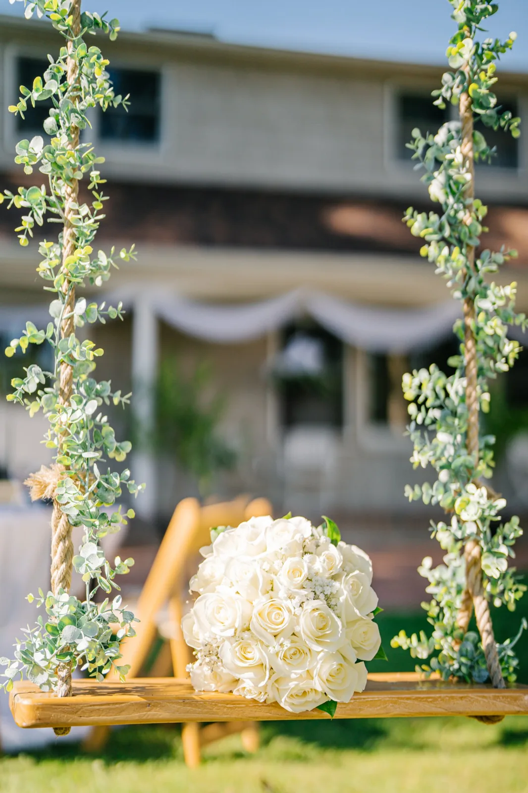 White rose bouquet on a eucalyptus-wrapped garden swing, Long Island backyard wedding details