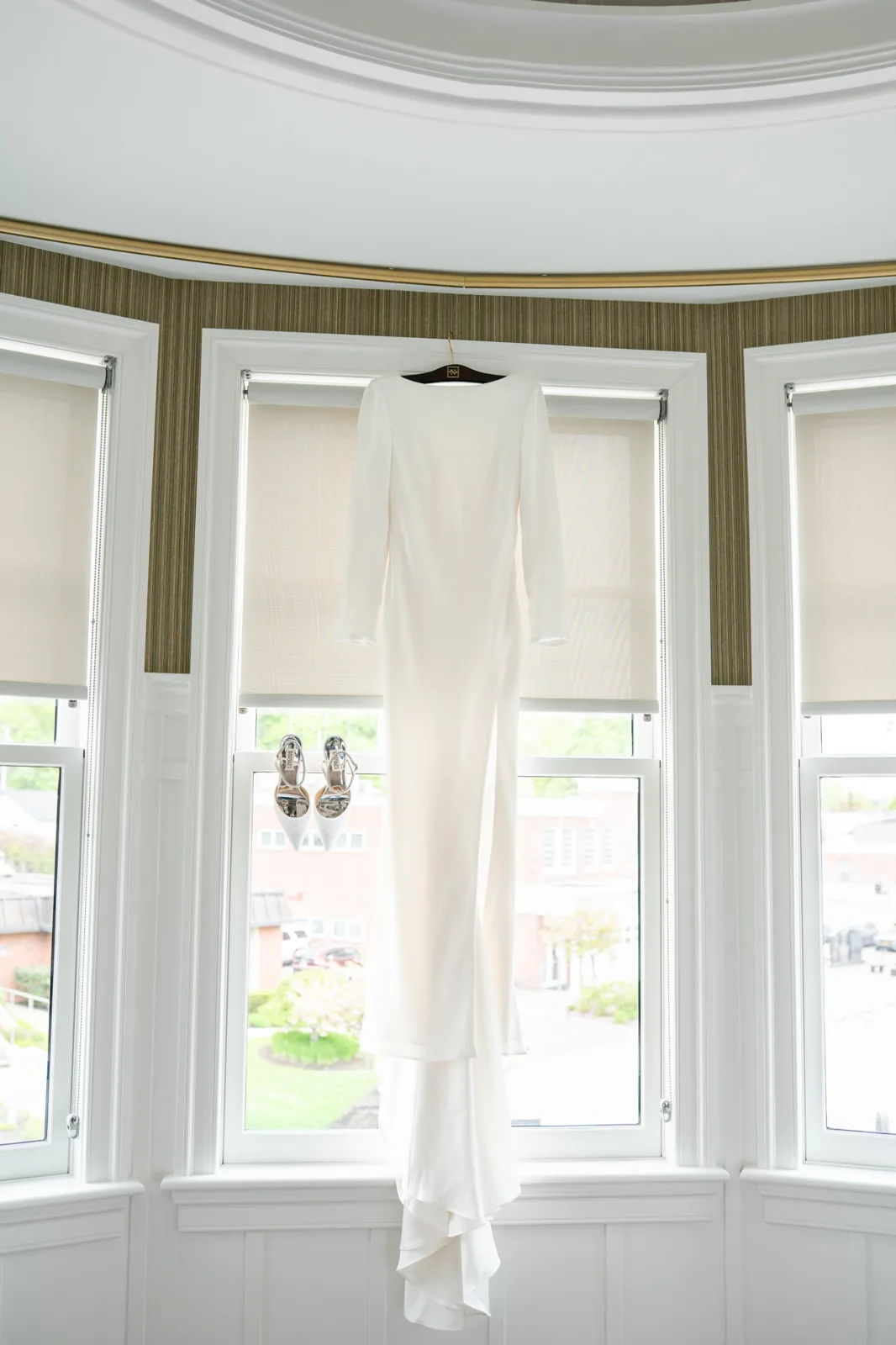 Wedding gown and heels hanging in a bay window, getting-ready details, Long Island wedding