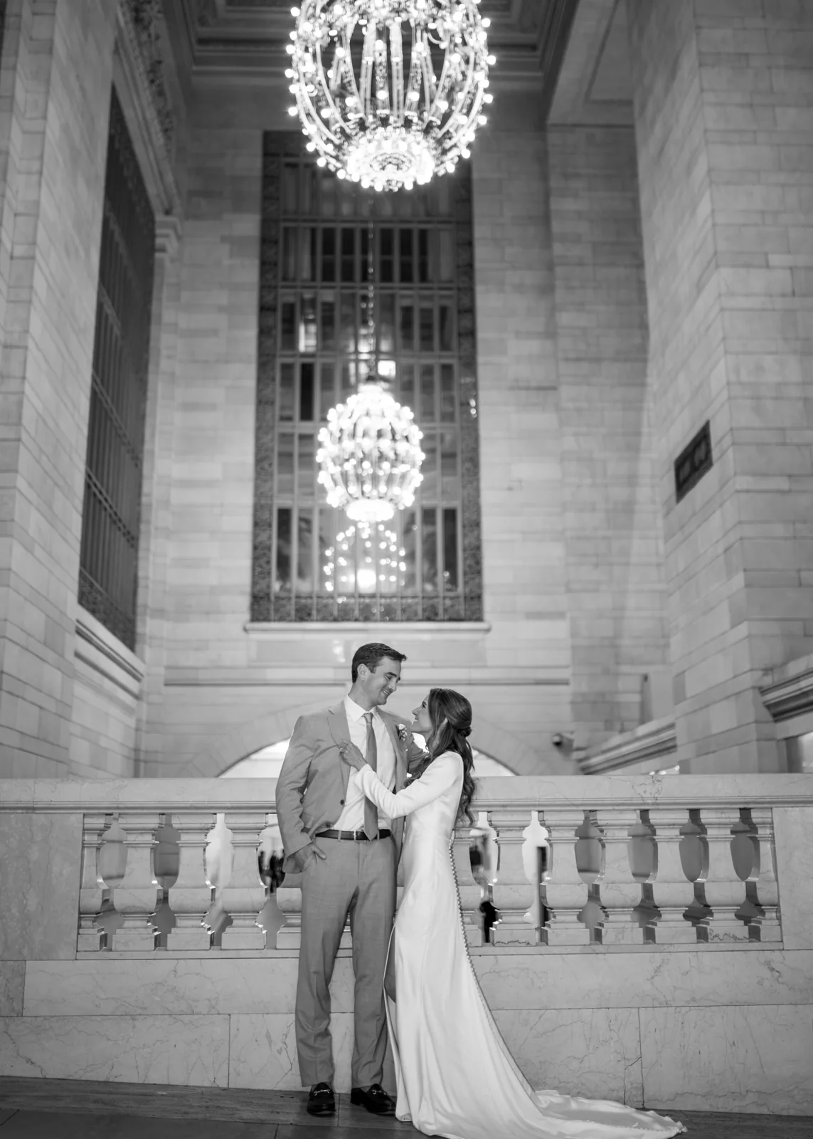 Bride and groom beneath the chandeliers at Grand Central Terminal, NYC wedding photography by Ashley Film Studios