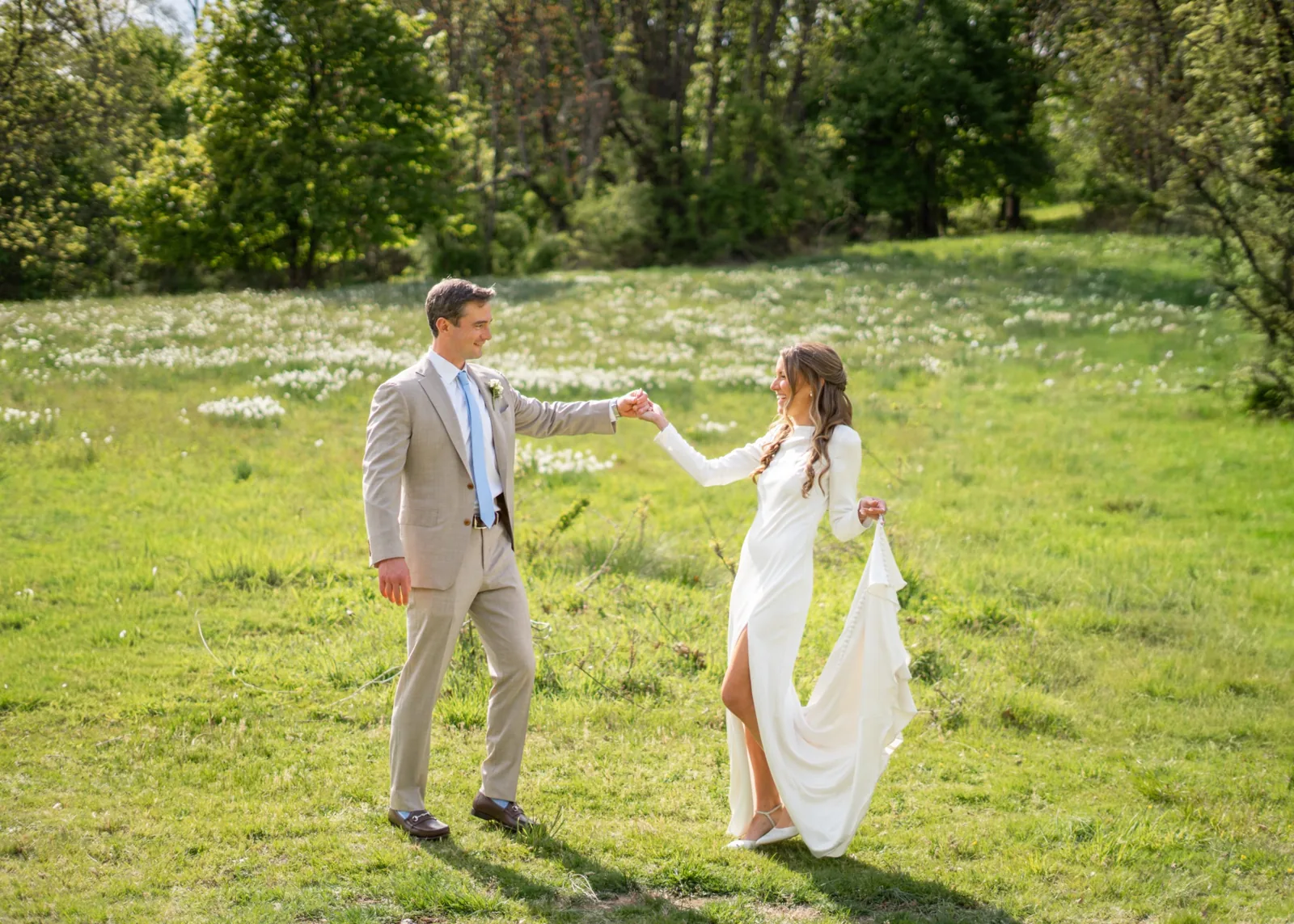 Groom twirls the bride through a wildflower meadow, Long Island wedding photography